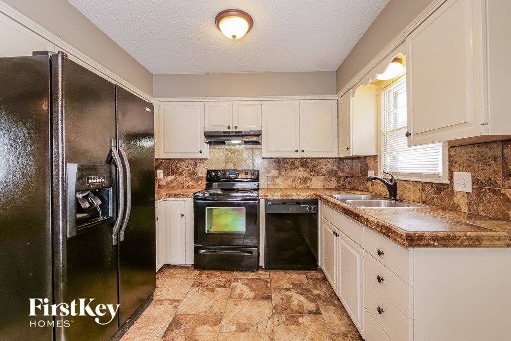 a kitchen with stainless steel appliances and white cabinets