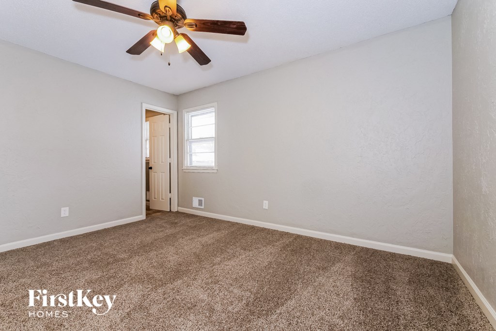 the living room of an empty house with a ceiling fan