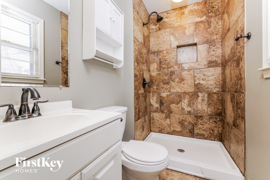 a bathroom with a toilet and a sink and a shower