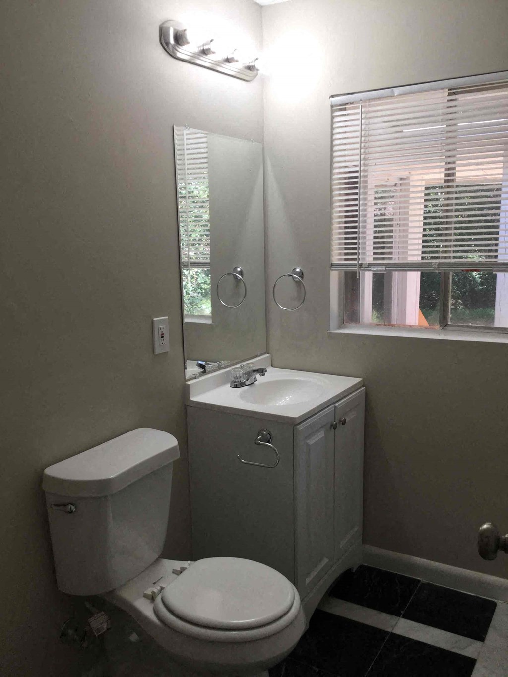 A white toilet sits next to a sink in a bathroom.