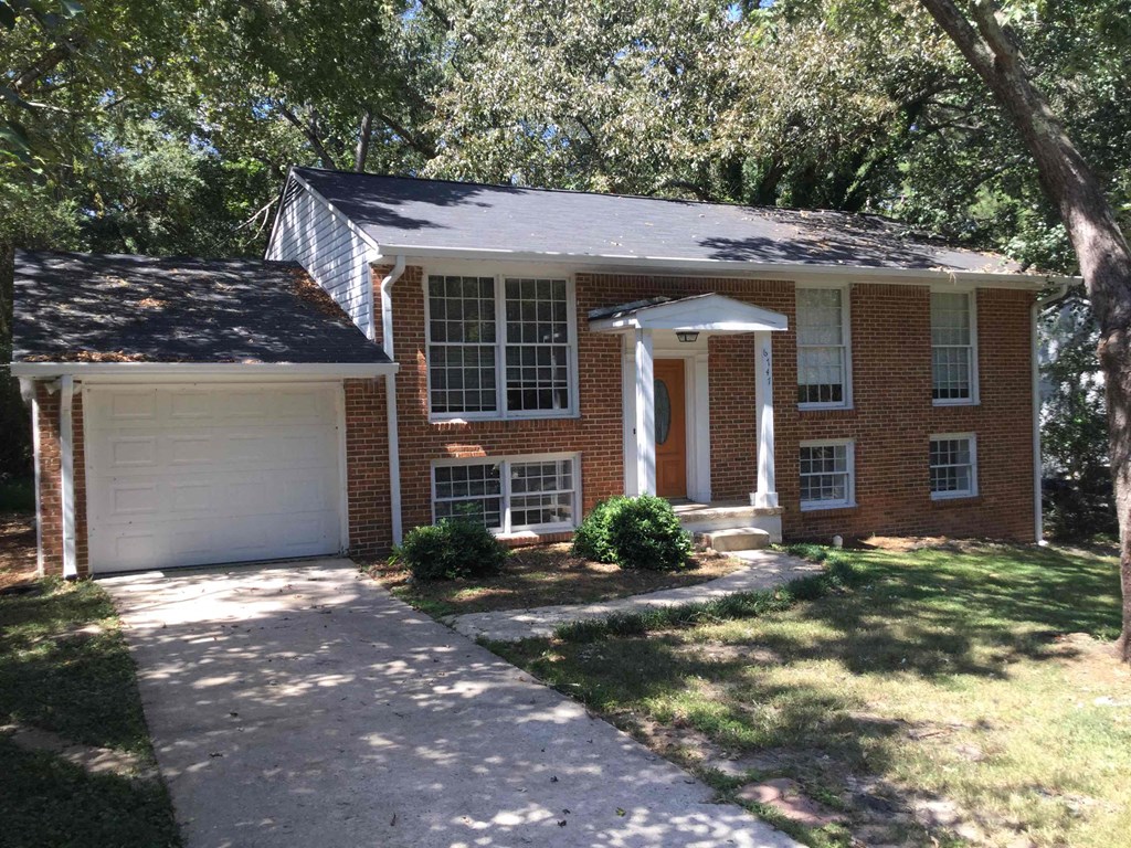A house with a white garage door and a brick facade.