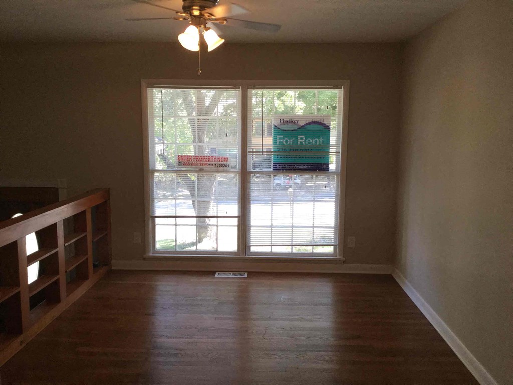 A room with a wood floor and a ceiling fan.