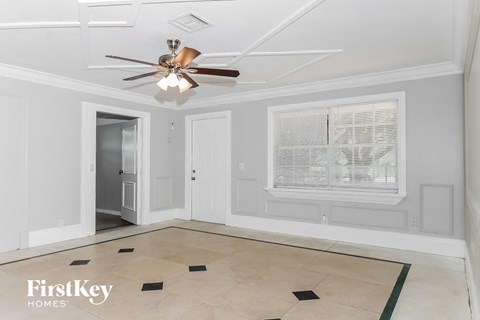 a living room with a ceiling fan and a window