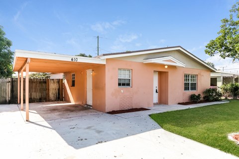 A house with a pink facade and a white roof.