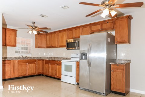 A kitchen with wooden cabinets and a stainless steel refrigerator.