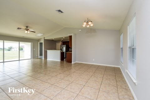 a large living room with tile flooring and a kitchen