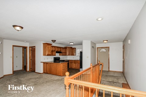 A spacious living room with a staircase leading to the upper floor.