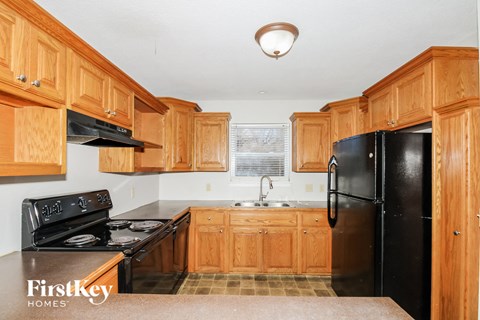 A kitchen with wooden cabinets and black appliances.