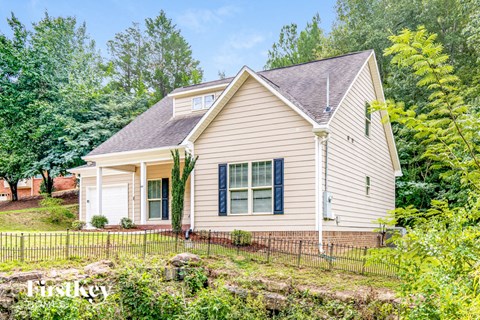 A house with a brown roof and a white fence.