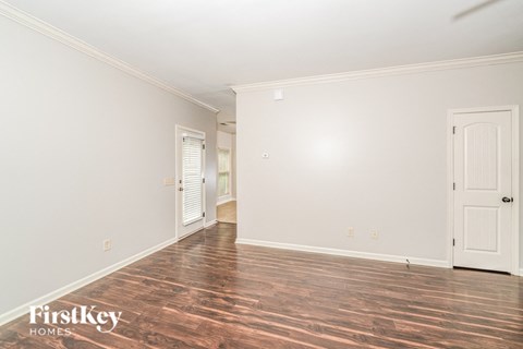 A room with wooden floors and two doors.