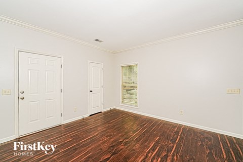 A room with wooden floors and two white doors.