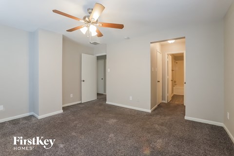 a living room with carpet and a ceiling fan