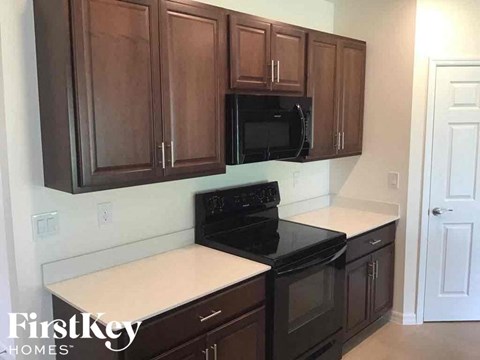 a kitchen with dark wood cabinets and a black stove