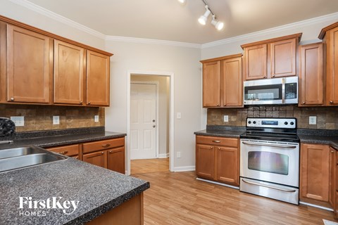 A kitchen with wooden cabinets and a granite countertop.