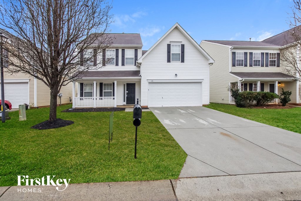 A white house with a black mailbox is for sale.