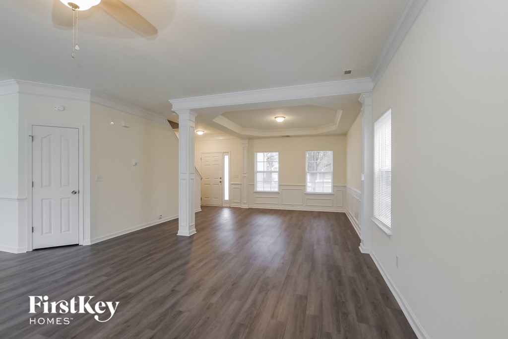 A spacious room with wooden floors and white walls.