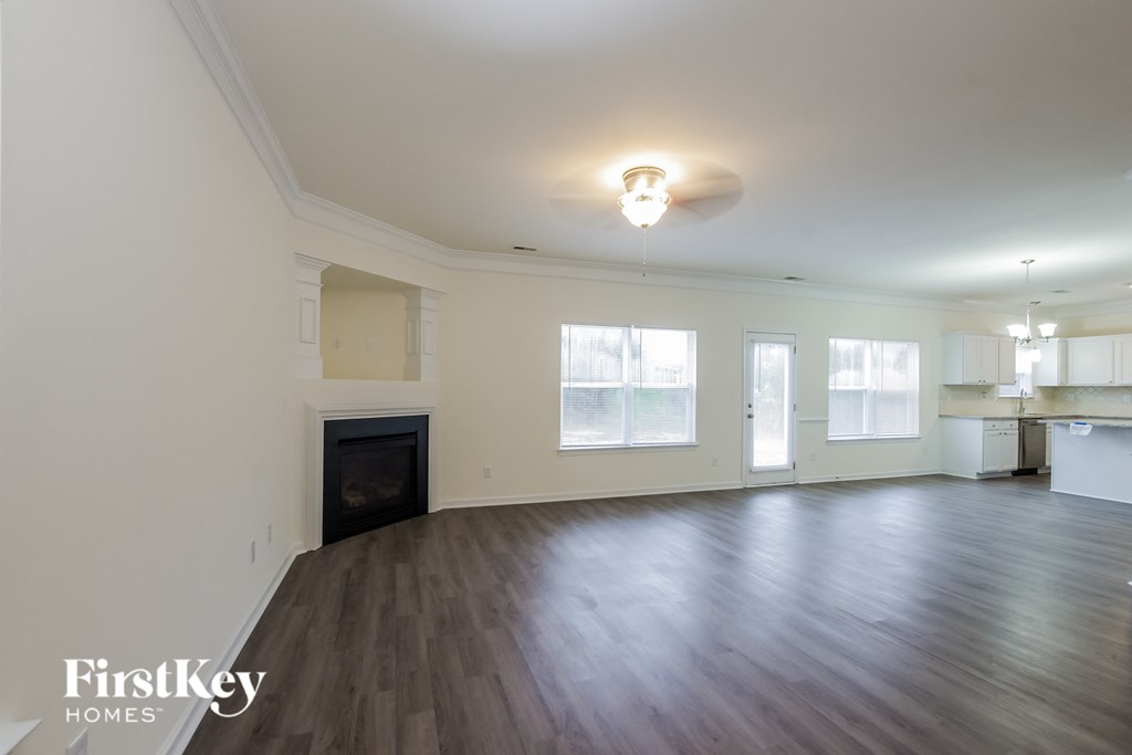 A spacious room with wood flooring and a fireplace is available for rent.