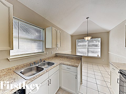A kitchen with a granite countertop and white cabinets.