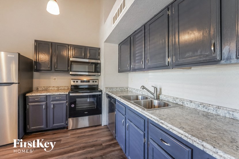 a kitchen with blue cabinets and stainless steel appliances and granite counter tops