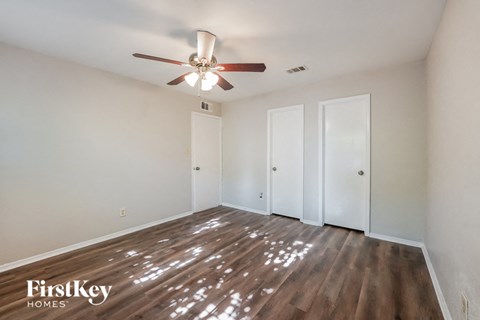 a living room with white walls and a ceiling fan