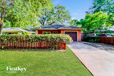 a red house with a garden and a sidewalk