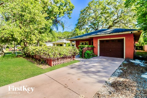 a red home with a driveway and a garage door