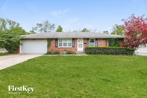 a small brick house with a lawn in front of it