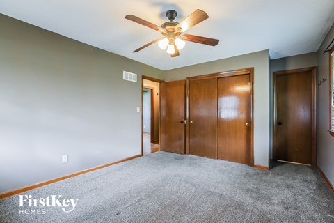 the master bedroom with carpeted flooring and a ceiling fan