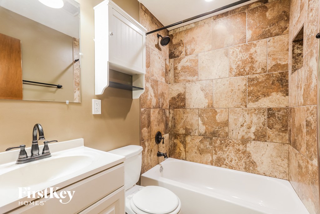 a bathroom with a sink toilet and bath tub