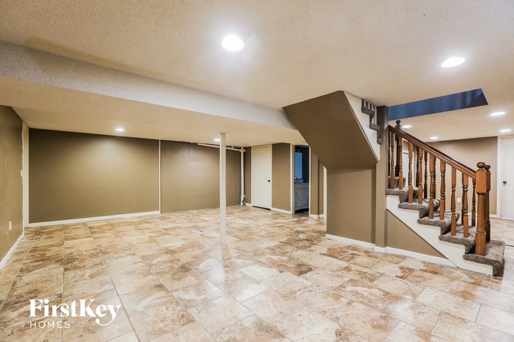 a spacious living room with a staircase and tile flooring
