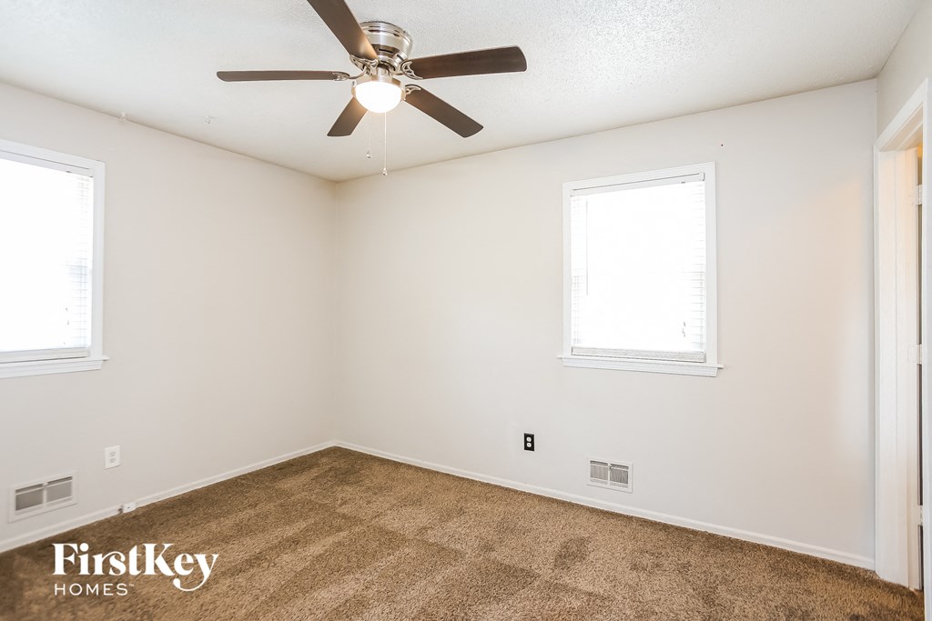 a living room with carpet and a ceiling fan