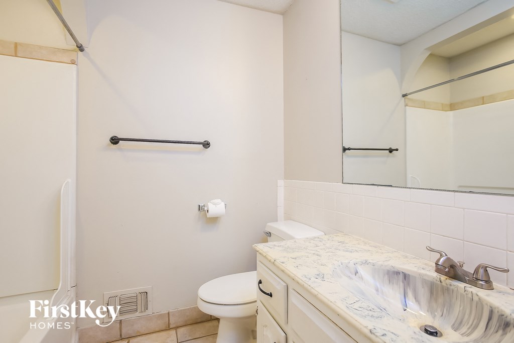a bathroom with a sink and a toilet and a mirror