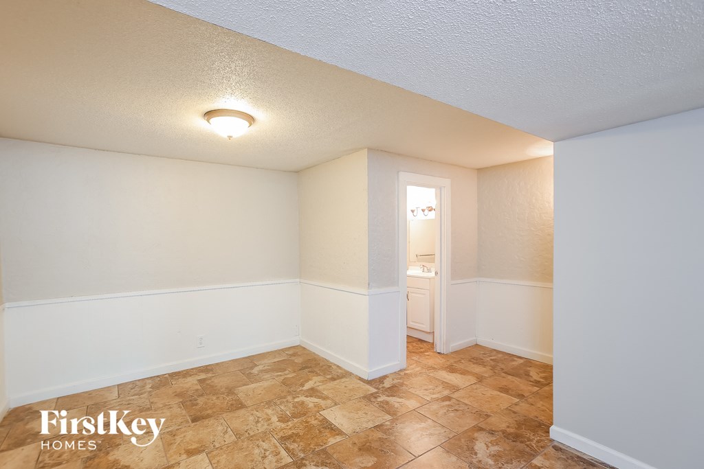 the living room of an empty house with a tile floor and white walls