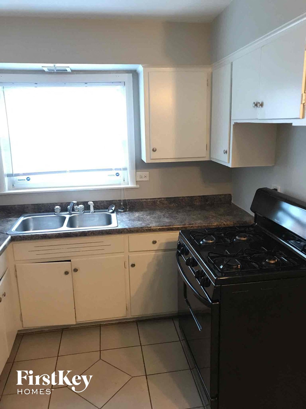 a kitchen with a stove and sink and a window