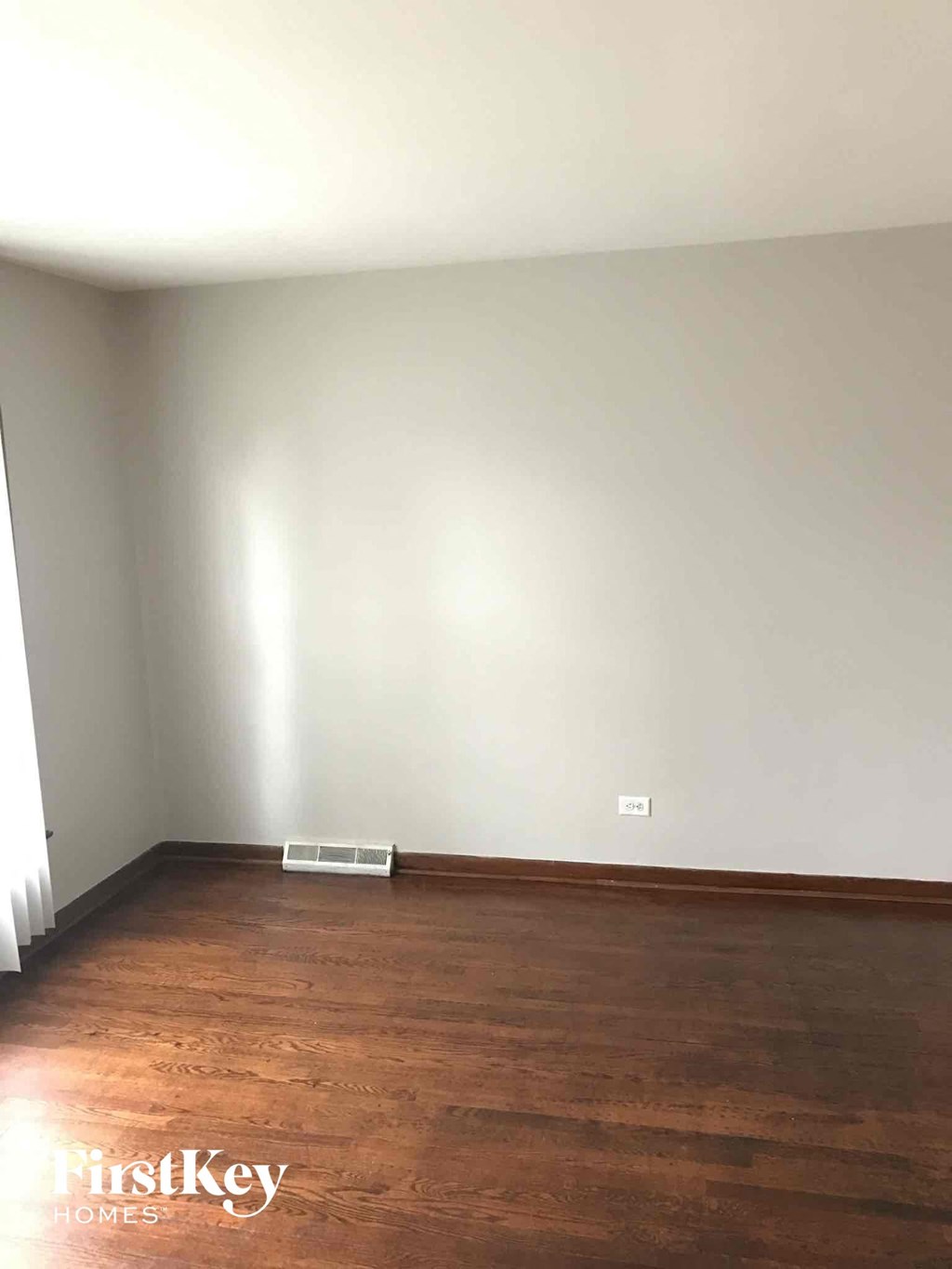 an empty living room with white walls and wooden floors