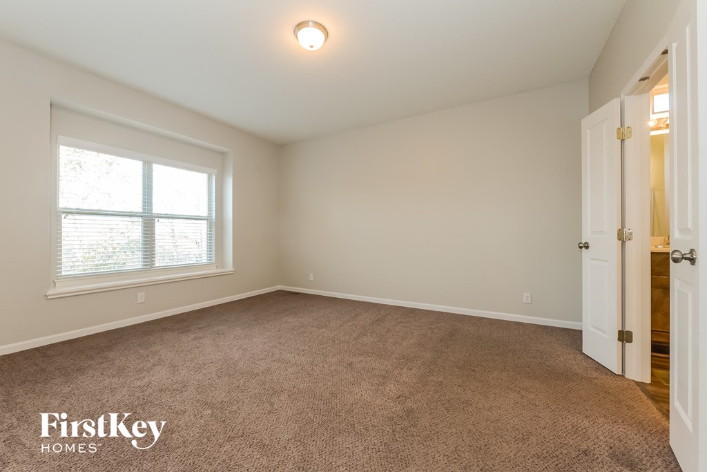 a bedroom with a carpeted floor and a large window