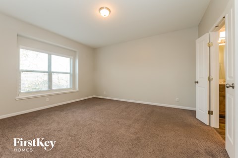 a bedroom with a carpeted floor and a large window
