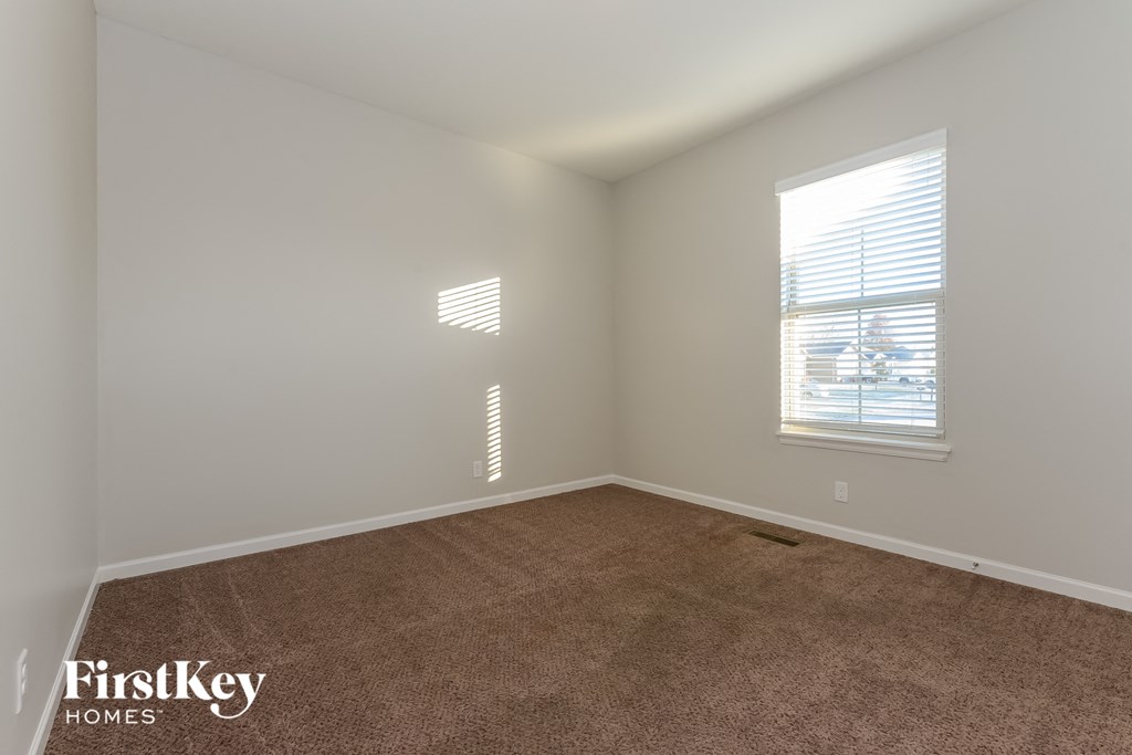 a bedroom with a carpeted floor and two windows