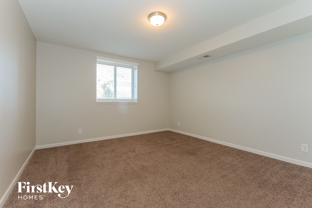 a bedroom with a carpeted floor and a window