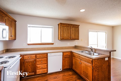 a kitchen with wooden cabinets and white appliances and a sink