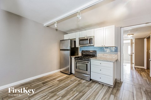 A kitchen with a stove top oven, microwave, and refrigerator.