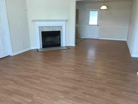 a living room with a fireplace and a wooden floor