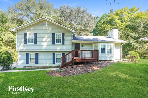 A house with a porch and a well-kept lawn.