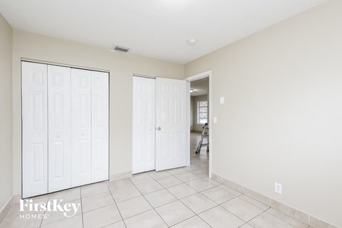 a bedroom with two closets and a tiled floor
