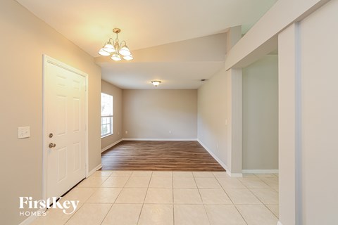 A spacious room with a door on the left and a window on the right.