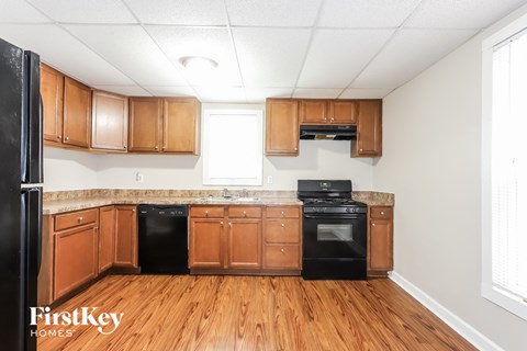 A kitchen with wooden cabinets and black appliances.