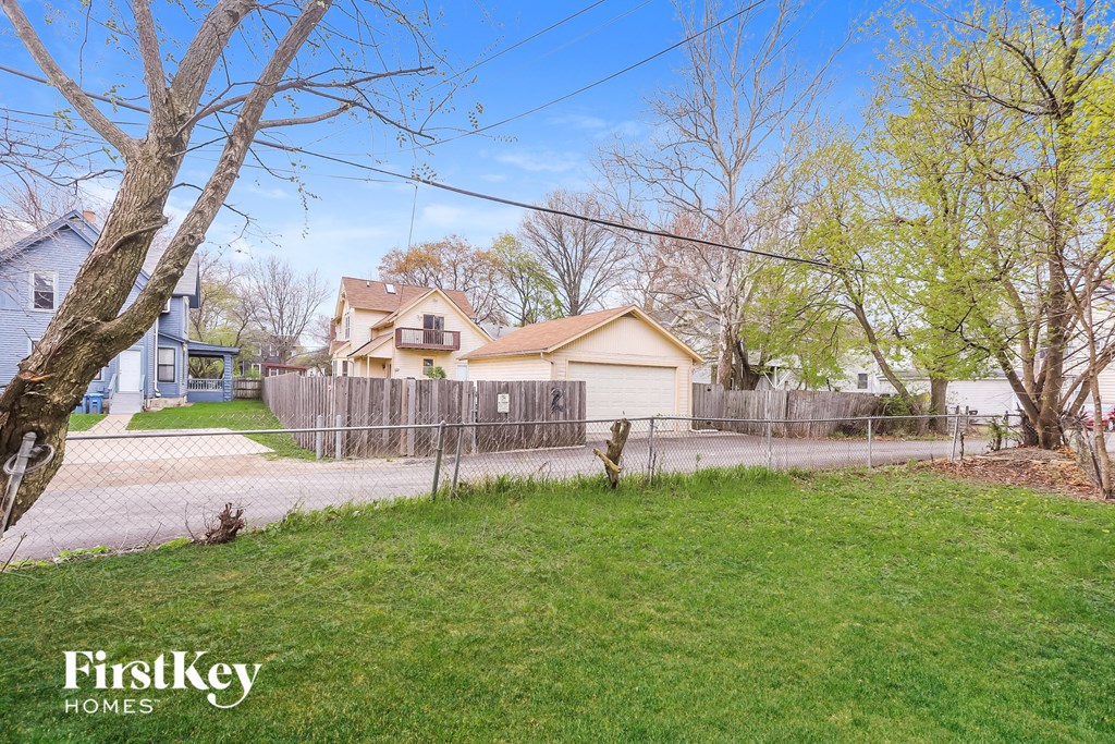 A house with a fence and trees in front of it.