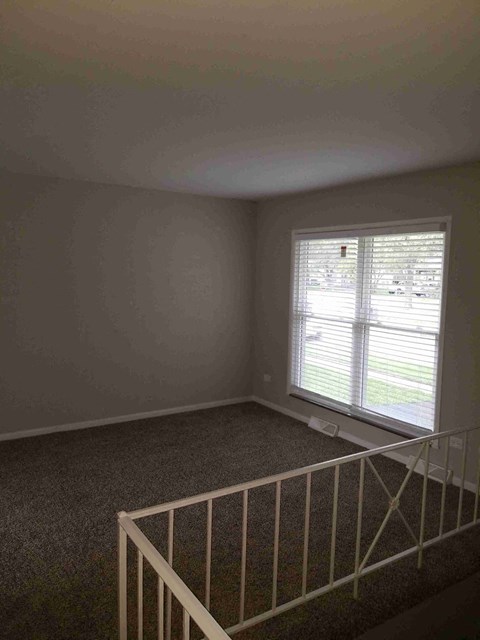 an empty room with a staircase and a window