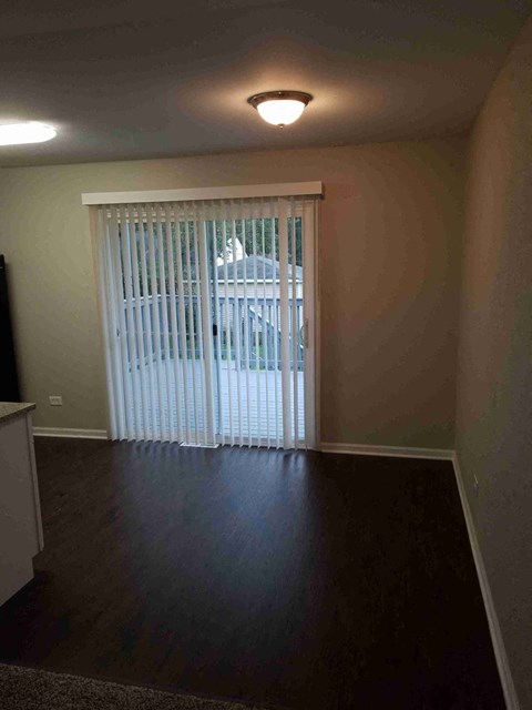 an empty living room with a sliding glass door to a patio