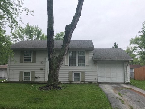 a white house with a tree in the yard